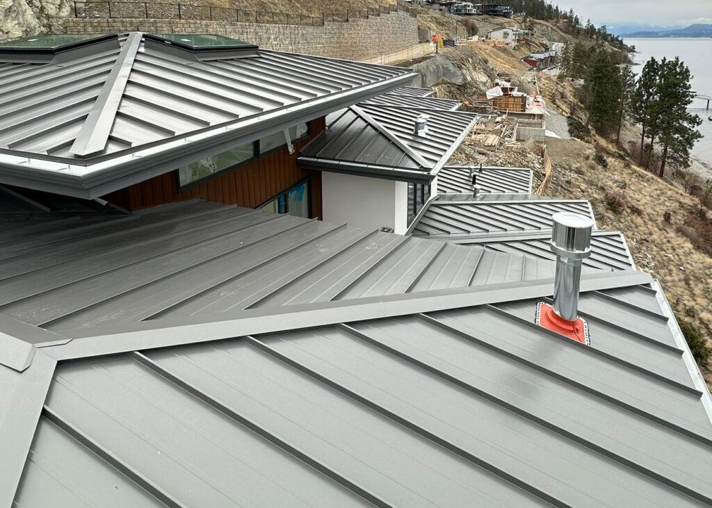 Close-up of a standing seam roof with custom-bent ridge and hip flashings