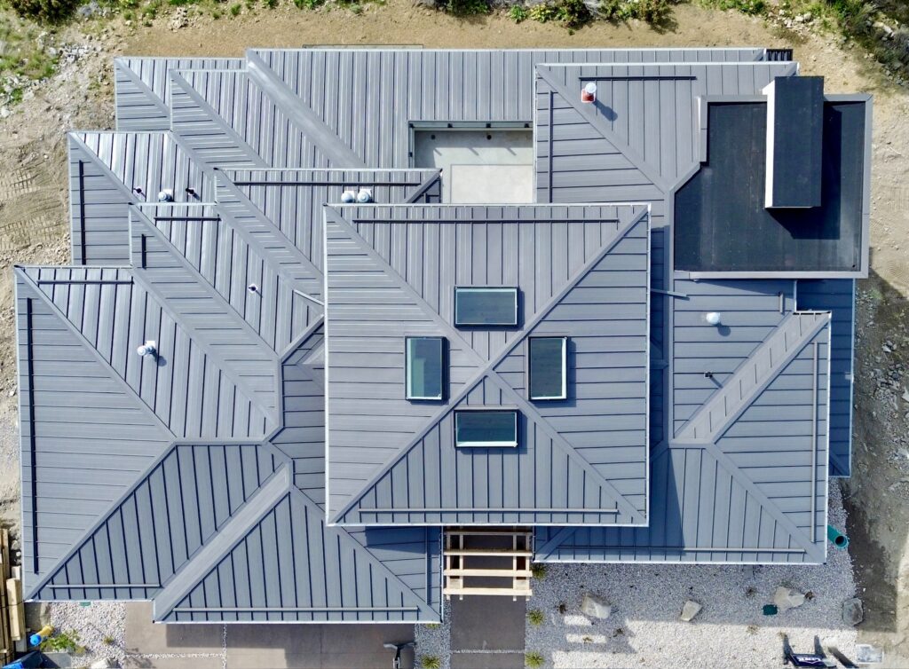 Aerial view of a complex standing seam metal roof with valleys, hips and skylights