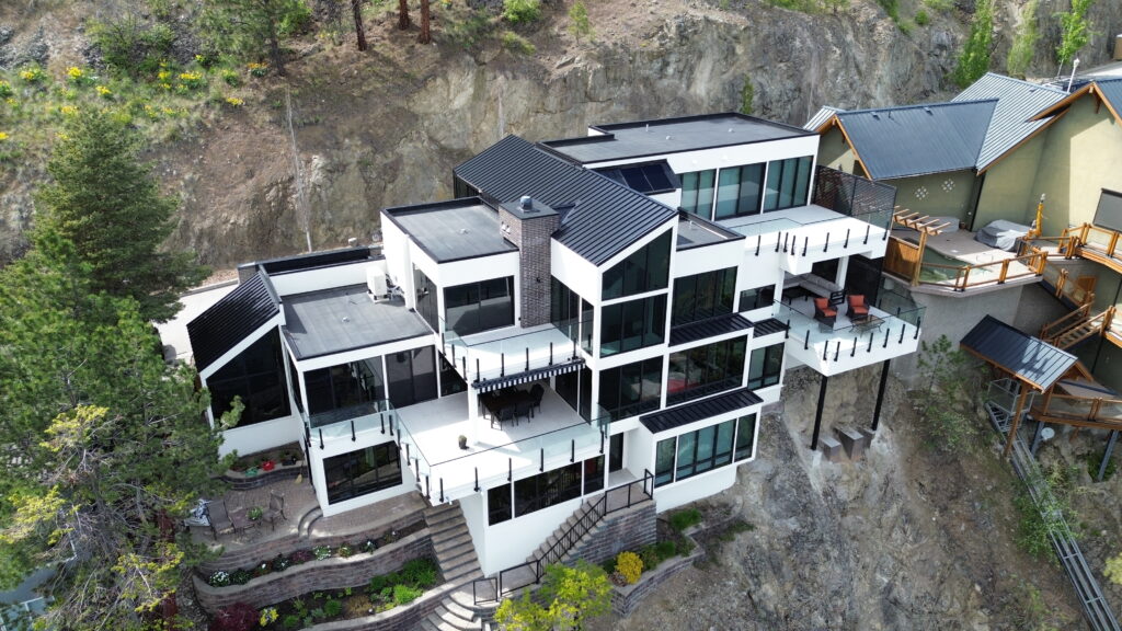 Modern multi-level hillside home with a black and white exterior in the Okanagan
